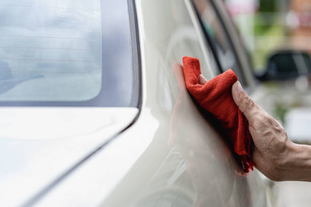 istock Man holding his car lights inspecting and cleaning 1450095867