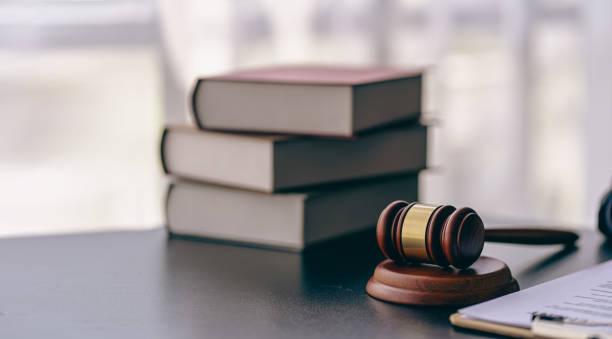 法廷での弁護士または裁判官のハンマーオークションハンマーはウーテーブルにあります。法律対象またはブックサインインオフィスのあるオークション会社