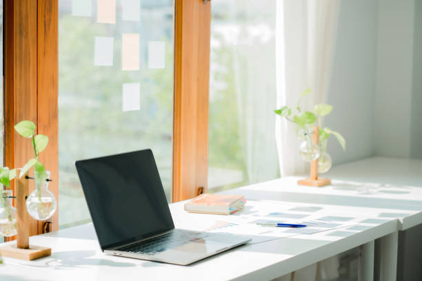 istock Laptop computer and financial graph on table in business office 1450096555
