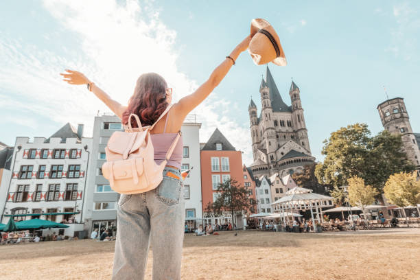 Happy tourist girl walks and enjoys vacations in the old town of Cologne at fish market square. Germany travel and sightseeing stock photo