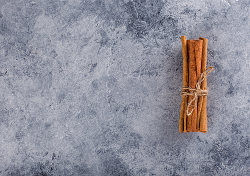 Cinnamon sticks on a concrete background. Place for advertising.