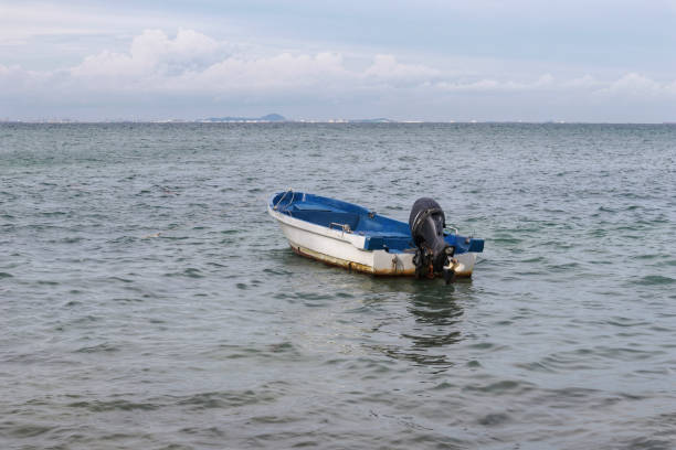 istock Small white paint motor boat and blue paint inside with nobody inside floating somewhere at the sea. 1450110188