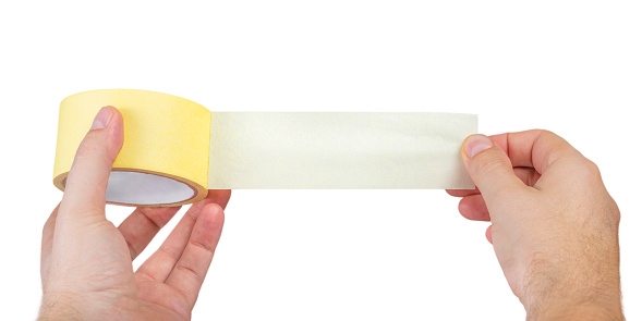 Paper adhesive tape isolated on white. A roll of paper duct tape in the hands of a white man. Unfolded adhesive tape with space for text