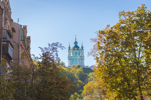 Kyiv, Ukraine - 09/22/2022: Saint Andrew church in Kyiv, view from Podol district. Church in autumn. Kyiv famous landmark. Religious architecture. Ortodox cathedral on sunny day.