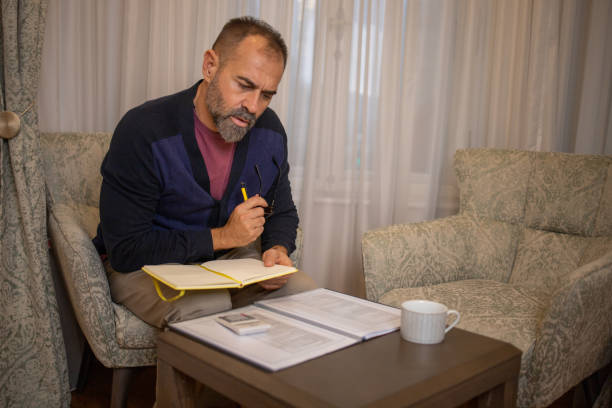 istock Mid adult man going through paperwork 1450112293
