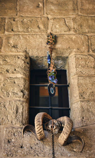 istock Evil eye beads and ram head accessories hung on the iron window wall in an old stone inn 1450115618