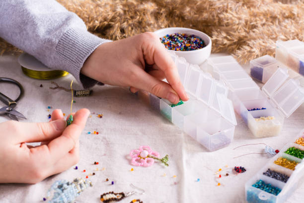 istock Children's hands take a bead and boxes with beads for weaving a bracelet 1450118576