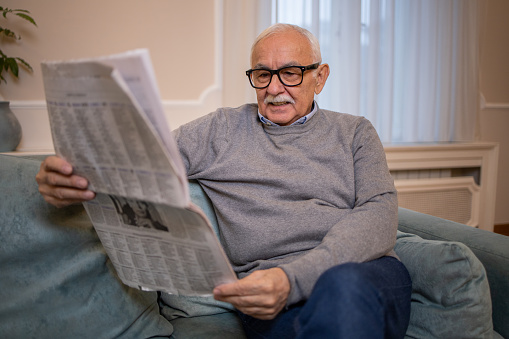 Handsome male business executive reading a newspaper