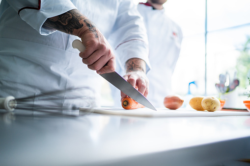 Chef chopping carrots in a domestic kitchen