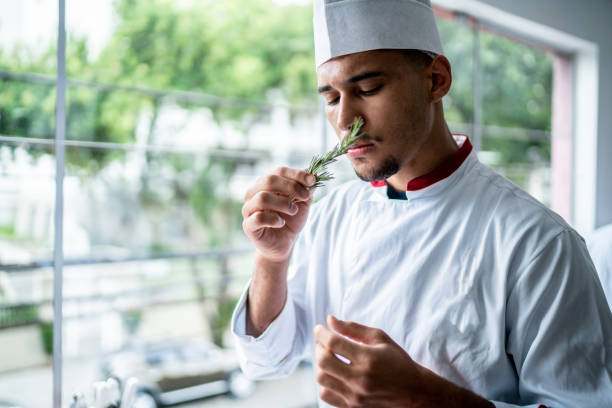 istock Chef smelling a branch of rosemary 1450127103