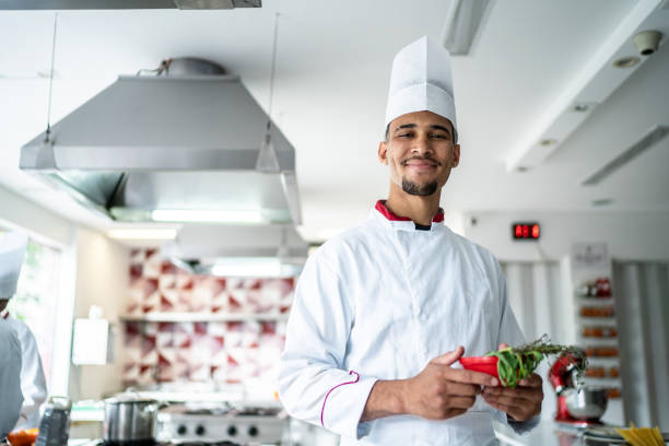 istock Portrait of a chef holding some herbs at the kitchen 1450127133
