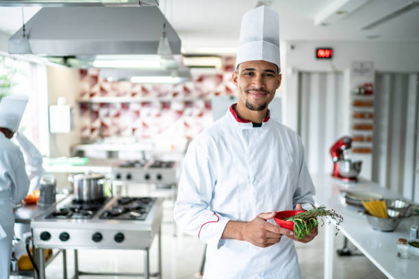 istock Portrait of a chef holding some herbs at the kitchen 1450127136