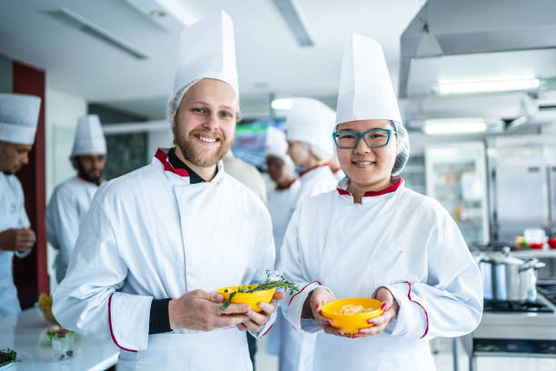 Portrait of chefs holding some herbs at the kitchen