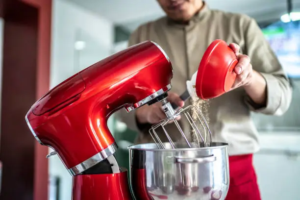 Chef pouring ingredients into a mixing bowl