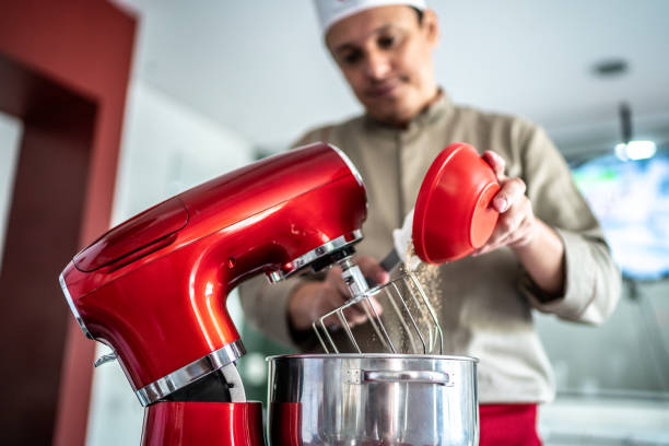 istock Chef pouring ingredients into a mixing bowl 1450128479