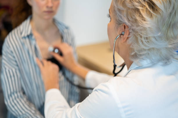 istock Doctor checking a young white woman's breathing and heartbeat 1450131809