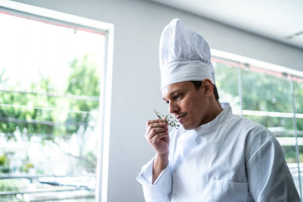 Chef smelling a branch of rosemary