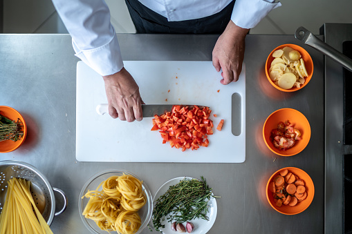 Directly above view of a chef chopping tomatoes