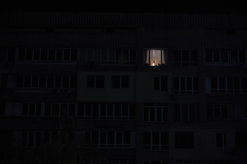 Light in one window in apartment multistorey building during the rolling blackout of electricity in a residential area of Kyiv after russian shelling