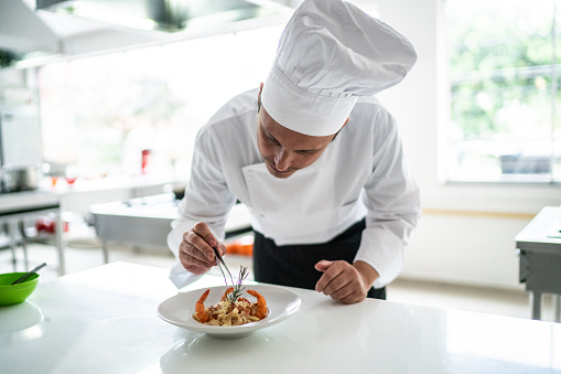 Chef arranging details in a pasta dish