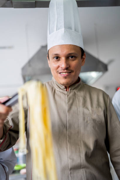 Portrait of senior man chef wear apron isolated on yellow background