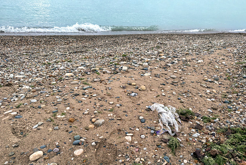 Plastic bag left behind on a stony beach