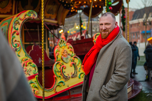 A middle aged redhead man at a Christmas Market Fairground