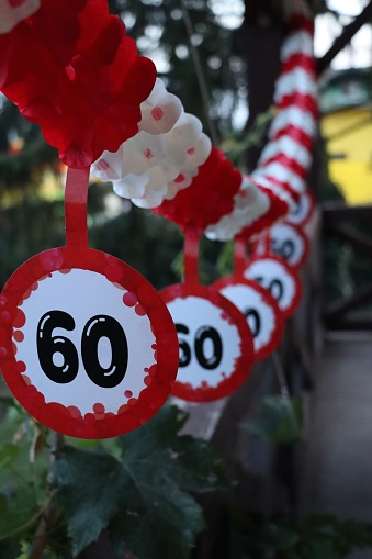 The red and white paper bunting stickers with the number 60 on them - the concept of a birthday party