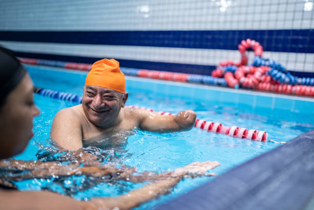 istock Mature man with a partial arm amputation is learning to swim in the swimming pool 1450164876