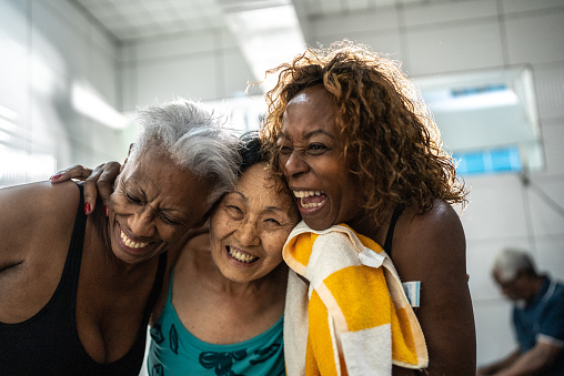 Senior women embracing in the swimming locker room