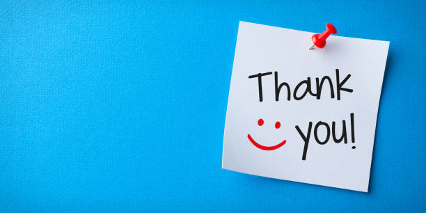 White Sticky Note With Thank You And Red Push Pin On Blue Cardboard stock photo