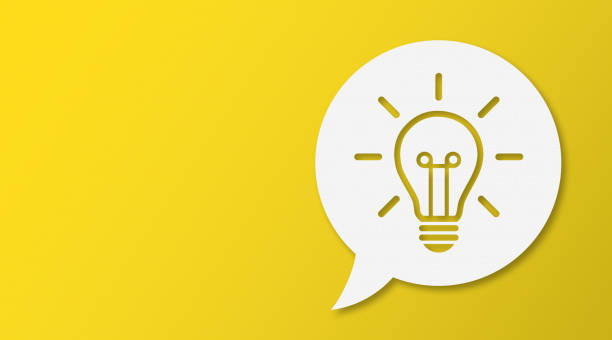 istock Light Bulb and Speech Bubbles with Copy Space On Yellow Cardboard Background 1450179017
