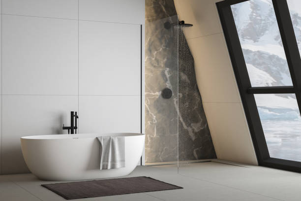 istock Modern bathroom interior with concrete floor, white oval bathtub and white basin, shower, plant and snowy mountain view from windows. Minimalist bathroom with modern furniture. 3D rendering 1450182356