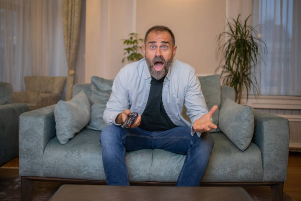 istock Man watching TV in the room 1450184529