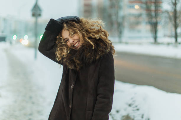 Curly woman outdoors in winter. stock photo