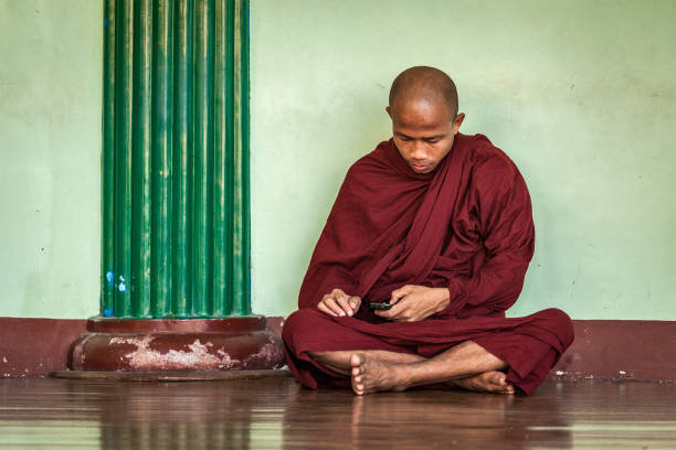 buddhist monk with phone in shwedagon pagoda - shwedagon pagoda fotos imagens e fotografias de stock