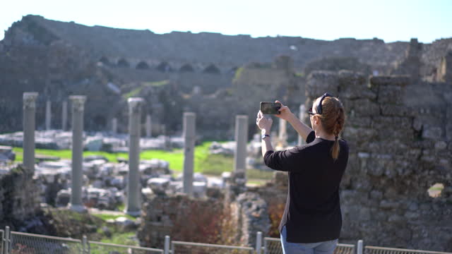 Tourist woman taking photo of the ancient city of Side Turkey