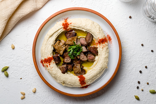 hummus with meat beef on white concrete table top view