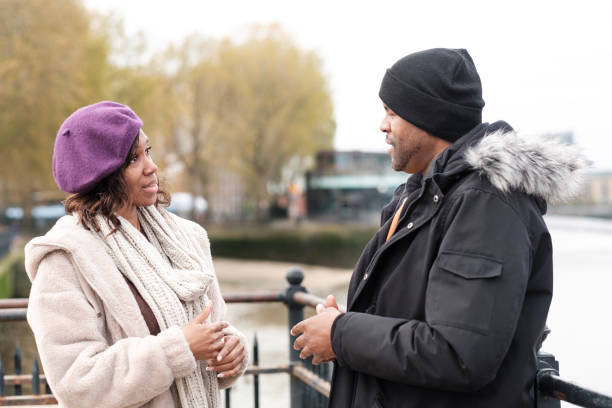 istock Two deaf friends are in the riverside Thames using sign language. 1450206249
