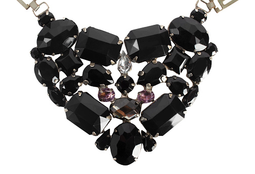Luxurious pendant with the shape of heart made of large black gemstones, close up, isolated.