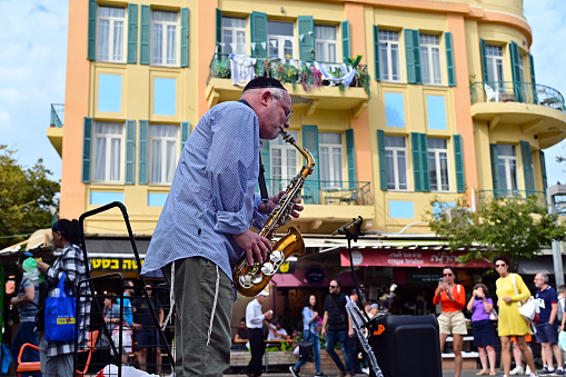 Tel Aviv Yafo - Nov 22 2022:Jewish saxophonist play music in street .The music of Israel is a combination of Jewish and non-Jewish music traditions that have come together over the course of a century
