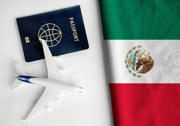 Flag of Mexico with passport and toy airplane. stock photo