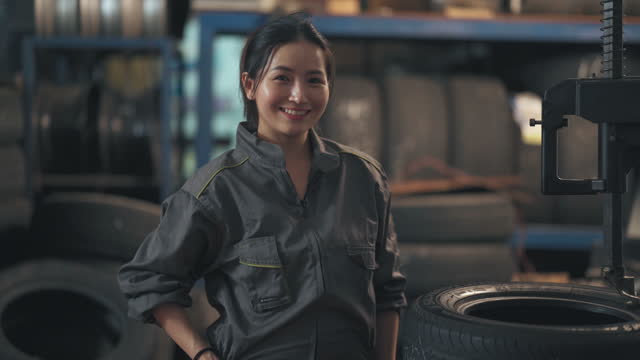 Portrait female mechanic worker looking at camera smiling in Auto repair shop