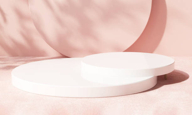 istock Two layer white glossy round podium on velvet table counter in dappled sunlight with tropical tree branch leaf shadow on pastel pink wall background 1450228797
