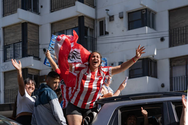 eine frau mit estudiantes de la plata-trikot feiert argentiniens gewinn der fifa fussball-weltmeisterschaft 2022 in katar. - argentina qatar stock-fotos und bilder