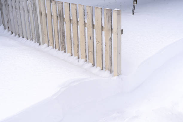 istock White wooden fence half covered with snow 1450231609