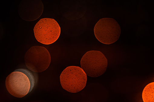 Large round bokeh from the night city with bright red hues. Display dust on the matrix.
