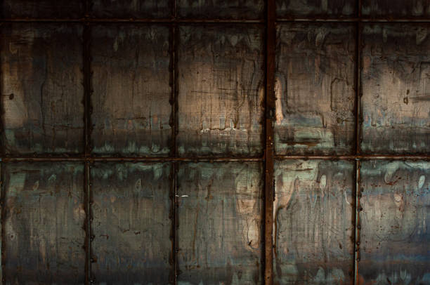 istock Background from a steel wall from sheets of iron welded together by corners. The process of rusting and destruction. 1450234631