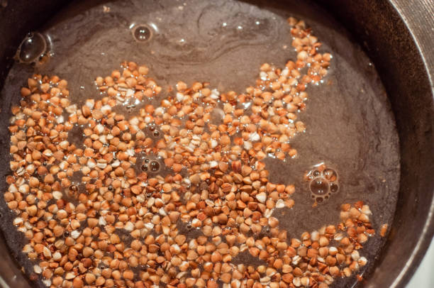 istock Buckwheat groats soaked before cooking in water in a cauldron. 1450234796
