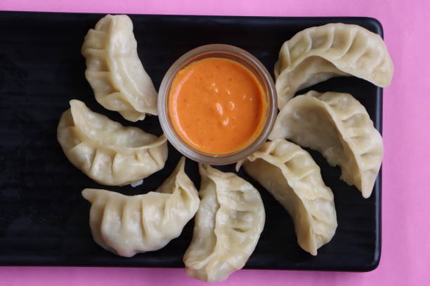 istock Traditional dumpling momos food from Nepal served with sesame chutney, Selective focus 1450236347